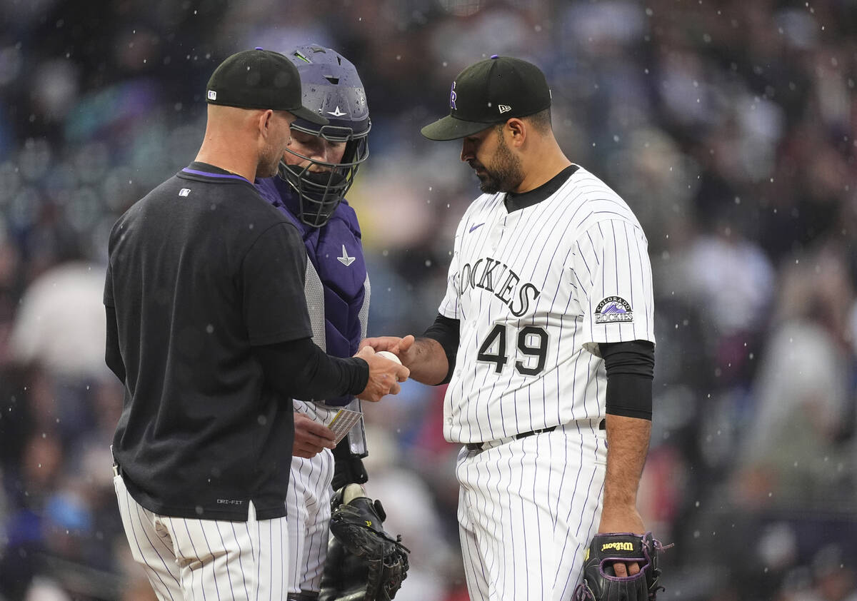 Colorado Rockies interim manager Warren Schaeffer, left, takes the ball from starting pitcher A ...