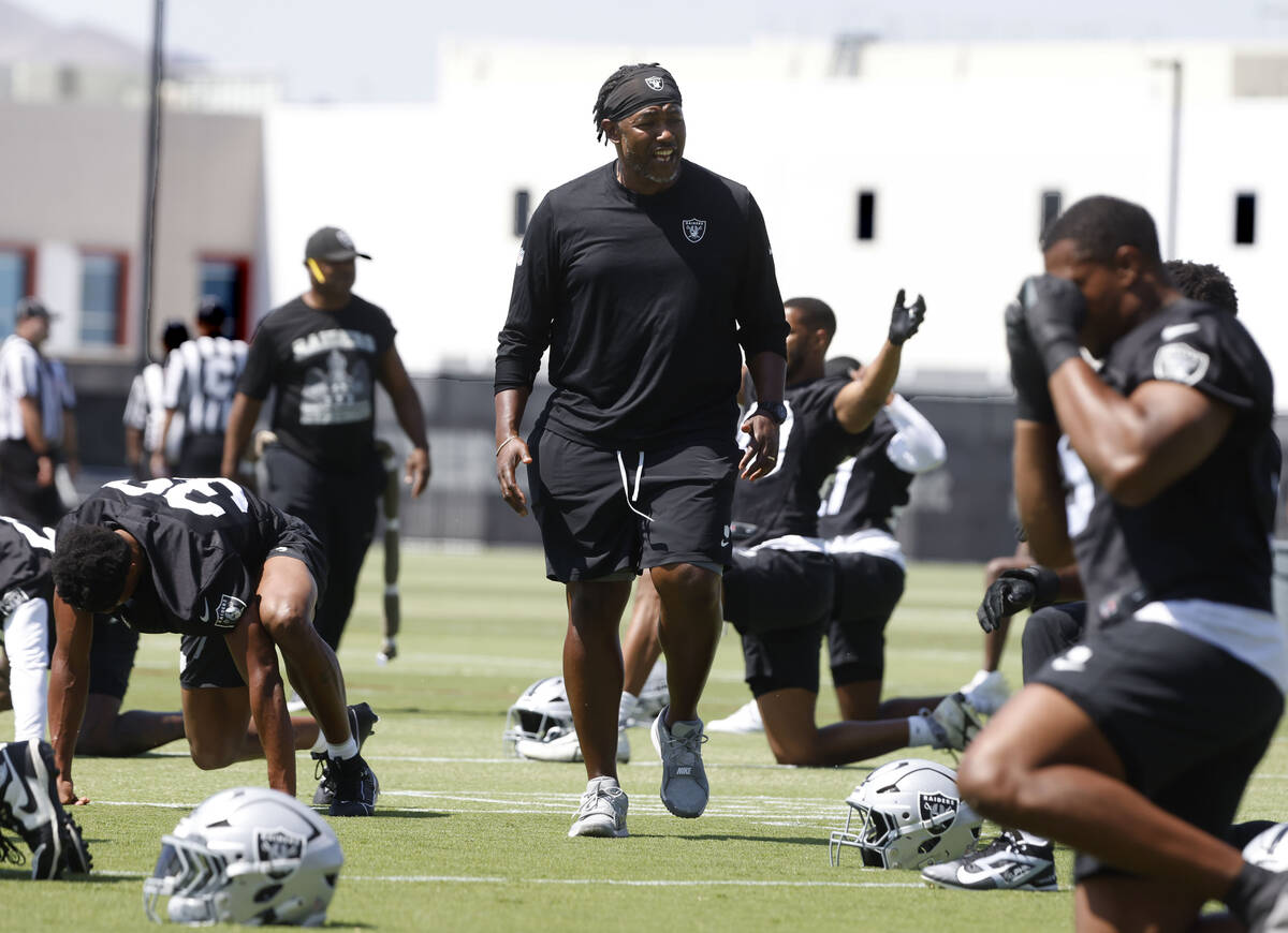 Raiders defensive coordinator Patrick Graham watches as players stretch during organized team a ...