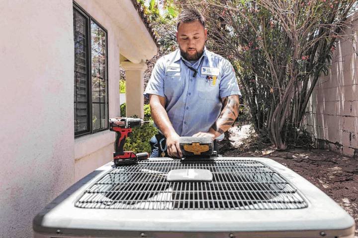 Service technician with Sahara Air Conditioning & Heating Jeremy Rojas repairs an air condition ...